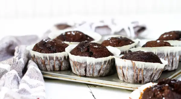 Mörka, saftiga chokladmuffins i pappersformar, redo att avnjutas. Ett perfekt chokladmuffins recept för fikat.