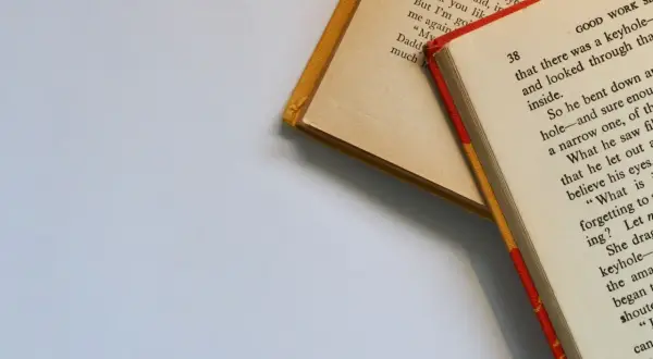 Dwie otwarte książki, jedna z żółtą okładką, druga z czerwoną. Wartościowe książki dla dorosłych, które wciągają w swój świat.