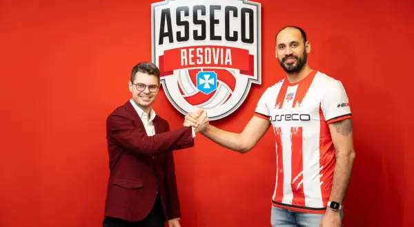 Mauricio Borges w koszulce Asseco Resovii ściska dłoń z mężczyzną w garniturze.