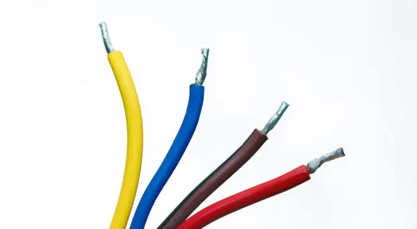 Quatre fils électriques dénudés : un jaune, un bleu, un fil bleu et marron, et un rouge, sur fond blanc.