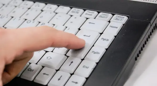 Palec naciska klawisz Enter na klawiaturze ultrabooka. Co to jest ultrabook? To lekki i cienki laptop.
