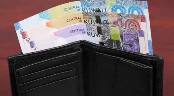 Czarny portfel z banknotami dinara kuwejckiego. Czy to najdroższa waluta świata?