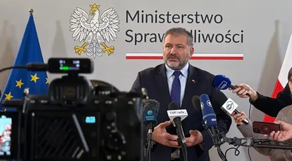 Minister sprawiedliwości przemawia do mediów, otoczony flagami Polski i UE. Dziennikarze zbierają materiał do reportażu o wyroku TSUE.