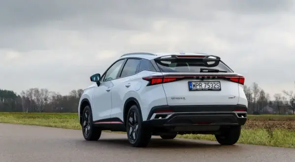 Biały, nowoczesny SUV OMODA S z charakterystycznym pasem świateł z tyłu. To jeden z nowych chińskich samochodów, który zyskuje popularność.