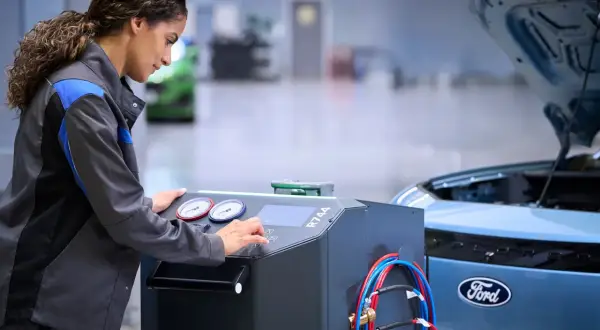 Mekaniker utför service på en Ford Focus. Maskinen indikerar att det är dags för ford focus serviceintervall.