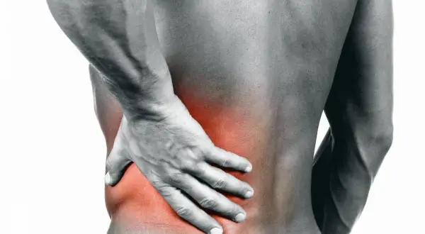 Uomo con mano sulla schiena, evidenziata un'area rossa di dolore. La sua lombosciatalgia acuta non passa.
