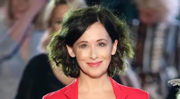 Uśmiechnięta Jolanta Fraszyńska w czerwonej marynarce, znana z wielu filmów, seriali i programów.
