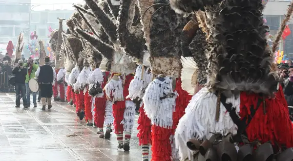 Un corteo di kukeri bulgari in costumi elaborati con piume e campanelli, pronti a scacciare il male.