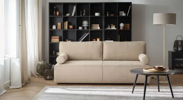 Przytulny salon z beżową kanapą i czarną biblioteczką. Gotowe aranżacje wnętrz, które inspirują do stworzenia własnej, stylowej przestrzeni.