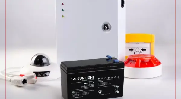 Batterie pour alarme filaire, assurant une longue durée de vie. Composants de sécurité visibles : caméra, sirène, centrale.