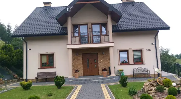 Piękny dom w Brzeźnicy z zadbanym ogrodem, kamienną ścieżką i ozdobnym kamiennym skalniakiem.