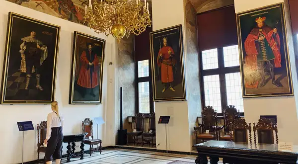 Wielka sala z portretami królów i bogatym żyrandolem. Sprawdź muzeum narodowe w gdańsku godziny otwarcia, by zobaczyć to na żywo.
