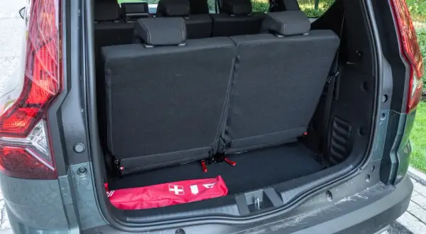 Bagażnik Dacia Jogger z rozłożonymi siedzeniami. W środku apteczka. Dacia Jogger opinie: praktyczny i przestronny.