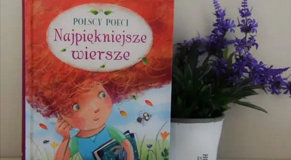 Książka "Najpiękniejsze wiersze polskich poetów" z ilustracją dziewczynki z rudymi włosami, obok doniczki z fioletowymi kwiatami.