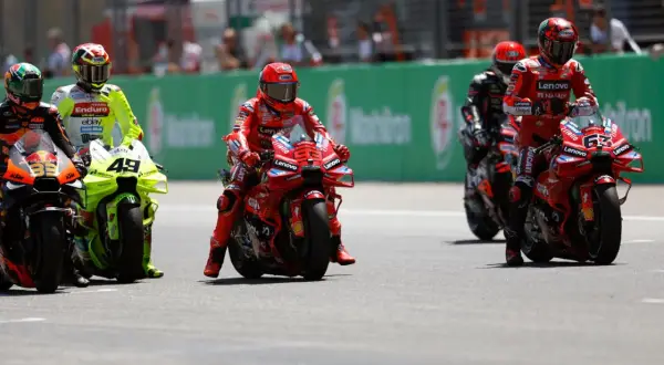 Pilotos de MotoGP en la parrilla de salida, listos para un intenso motogp test. El número 63 de Ducati destaca.