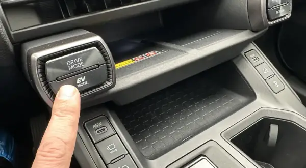 Palec naciska przycisk EV MODE na panelu Toyota. Dowiedz się, co to drive mode Toyota i jak wpływa na jazdę.