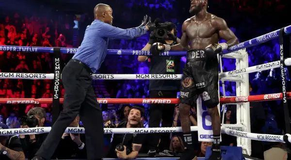 Referee stops the fight, signaling the end. Deontay Wilder stands, exhausted but victorious, as the crowd roars.