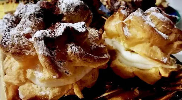 Dolci "teste di turco" con crema soffice e zucchero a velo, un piacere per gli occhi e il palato.
