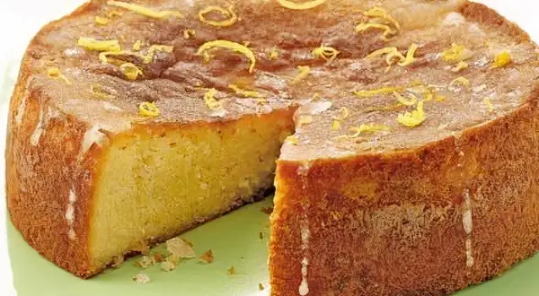Szybkie ciasto bezglutenowe, lekko zarumienione, z cytrynową skórką na wierzchu, prezentuje się apetycznie.