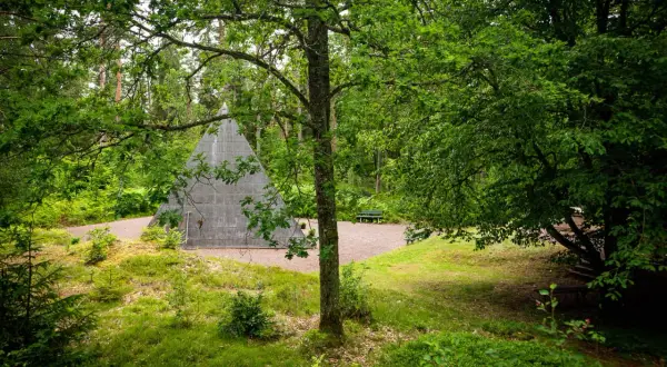 En grå pyramid reser sig ur en lummig skog. En perfekt plats för udda utflykter i Småland, med bänkar för vila.