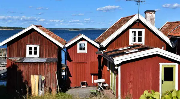 Röda stugor vid vattnet, en idyllisk vy från Sandhamn camping.