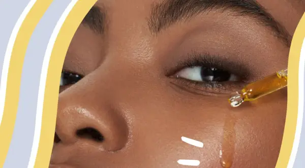 Ein Tropfen goldenes Öl mit Vitamin E wird auf die Haut aufgetragen, um sie zu pflegen.