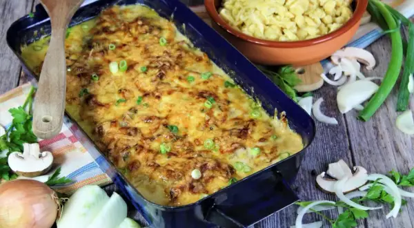 Zwiebel Sahne Schnitzel, überbacken mit Käse, daneben Spätzle, Zwiebeln und Pilze.