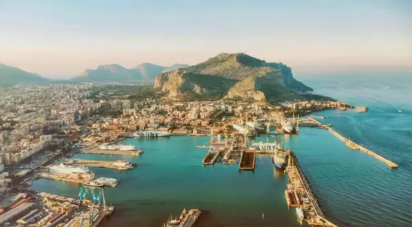 Palermo mit Kindern: Ein Blick auf den Hafen mit Schiffen und dem Monte Pellegrino im Hintergrund. Perfekt für einen Familienausflug!
