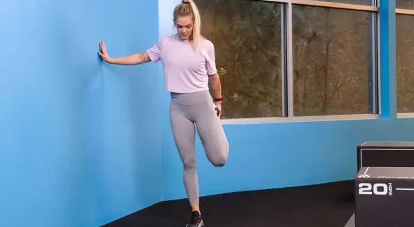 Donna esegue stretching quadricipiti, un ottimo esercizio per la gonalgia al ginocchio.