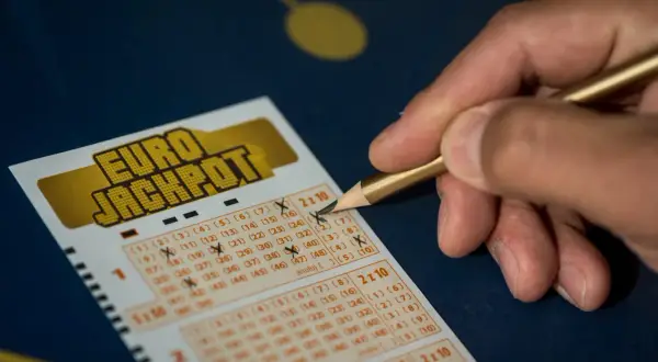 Dłoń z ołówkiem zaznacza liczby na kuponie Eurojackpot. Zastanawiasz się eurojackpot do której godziny? Sprawdź, zanim będzie za późno!