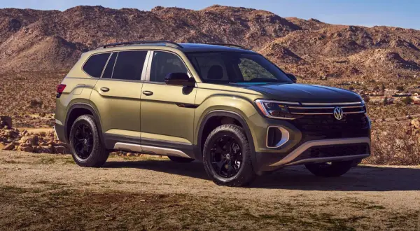 Zielony VW Atlas z czarnymi felgami na tle pustynnego krajobrazu.