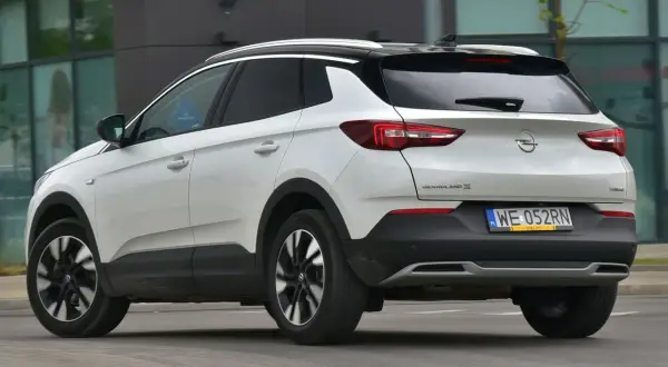 Biały Opel Grandland X z czarnym dachem, z tyłu. Zastanawiasz się, opel grandland x jaki silnik wybrać?