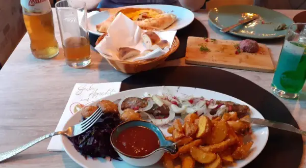 Ein köstliches Gericht mit Fleischspieß, Kartoffelspalten und Rotkohl in einem georgischen Restaurant in Halle.