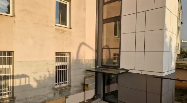 Nowoczesny blok z jasną elewacją i przeszklonym wejściem. Poznaj, jak zapisać adres mieszkania w bloku, by listonosz go odnalazł.
