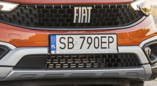 Pomarańczowy Fiat z tablicą rejestracyjną SB 790EP. Detale przedniego grilla i logo marki.