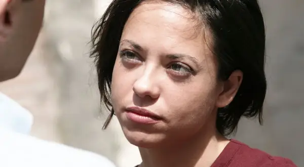 Mujer con mirada perdida, reflexionando sobre como dejar a un maltratador.