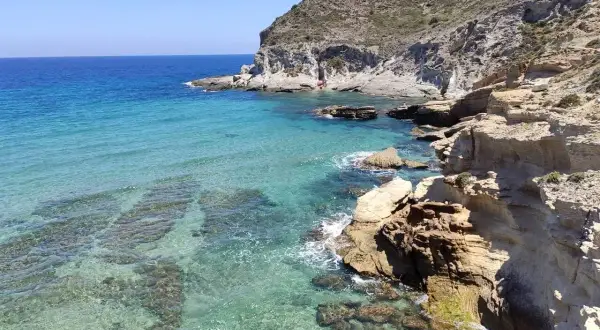 Aguas cristalinas y acantilados rocosos en un día soleado. Un rincón perfecto para unas vacaciones en Cabo de Gata.
