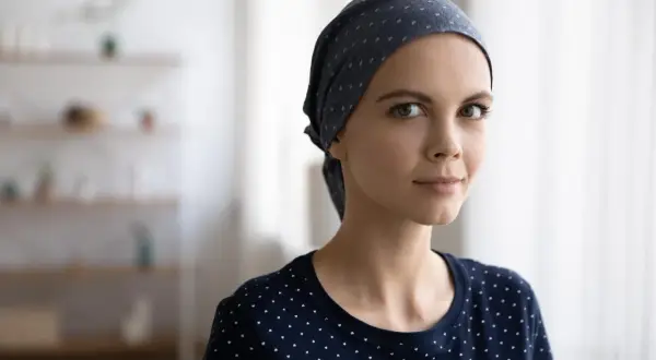 Młoda kobieta w chustce na głowie, symbolizująca siłę i nadzieję przed chemioterapią.