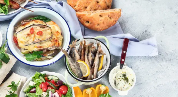 Un festin méditerranéen : brochettes, moussaka, poisson frit, salade grecque, pain et sauce. Un menu de la semaine alléchant !