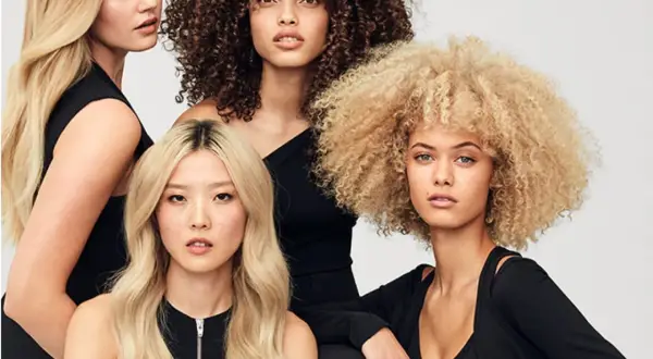 Fyra kvinnor med olika hårtyper: rakt, lockigt och afro. Alla har slitet hår som ser friskt ut.