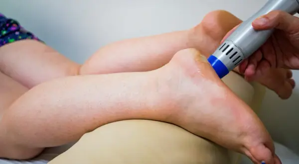 Behandlung eines Fußes mit einem Ultraschallgerät, um neurologische Ursachen für Krallenzehen zu lindern.