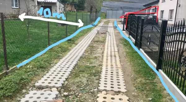 Wyznaczona odległość wiaty od drogi wewnętrznej to 10m. Widać tu dwa pasy z kostki ażurowej prowadzące do posesji.