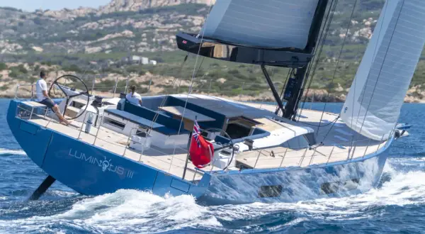 Il Solaris 74 "Luminous III" naviga con vele spiegate, solcando le onde blu. Due persone a bordo godono della brezza marina.