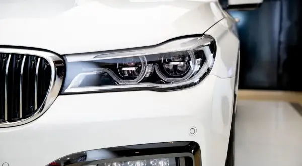 Biały, luksusowy samochód z chromowanym grillem i nowoczesnymi reflektorami. Idealny do ubezpieczenia samochodu powyżej 150 tys.