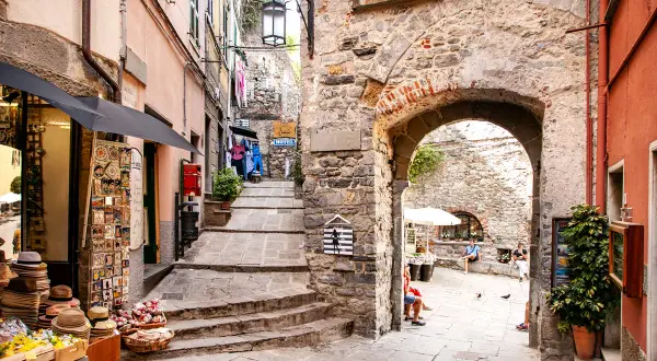 Un vicolo pittoresco nel portovenere centro storico, con negozietti, scalinate in pietra e un arco antico.