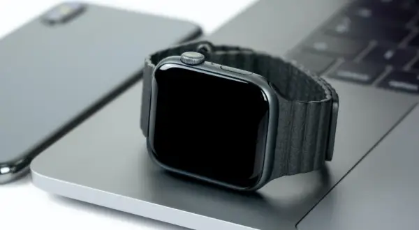 Smartwatch nie działa wyświetlacz. Czarny ekran zegarka na tle laptopa i telefonu.