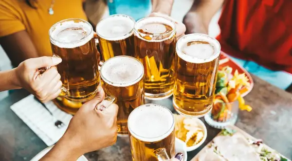 Brindisi con birra season! Amici brindano con boccali di birra dorata, un momento di gioia e condivisione.
