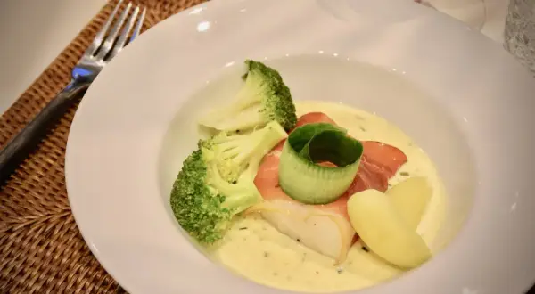 En vacker tallrik med fisk, broccoli och potatis i en krämig sås. Perfekt för en middag med vin till Sandefjordsås.