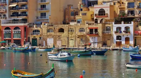 Malta, z kolorowymi łodziami i kamiennymi budynkami. Czy na Maltę potrzebny paszport? Tak, jeśli nie jesteś obywatelem UE.