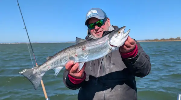 Glücklicher Angler hält stolz einen großen Fisch, den er beim Limburg Angeln gefangen hat.